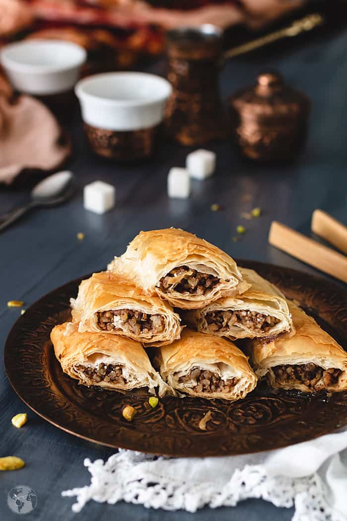 Rolls of Mediterranean baklava stacked on a plate.