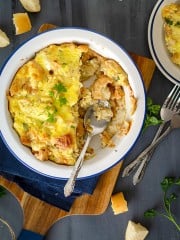 A dish of stale bread, feta cheese, and onions with a spoon resting in it.