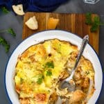 White baking dish with half-eaten bread pudding on a wooden cutting board