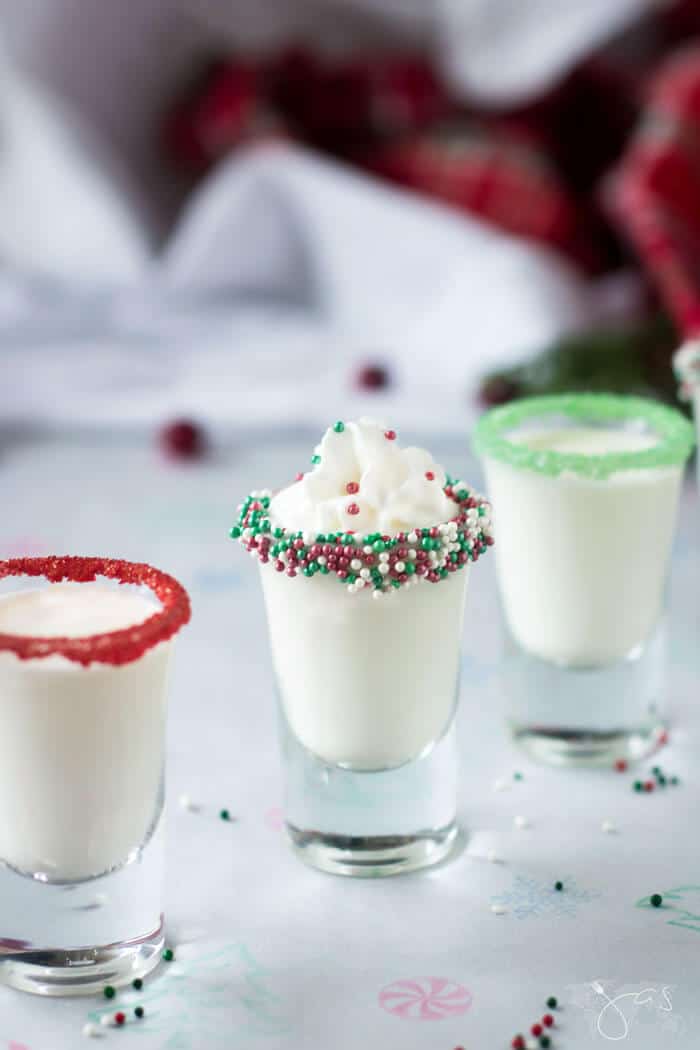 Shot glasses with cocktail, sprinkles, and whipped cream