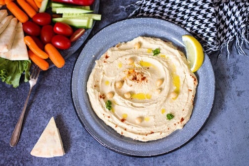 Homemade Hummus on a plate with lemon wedge