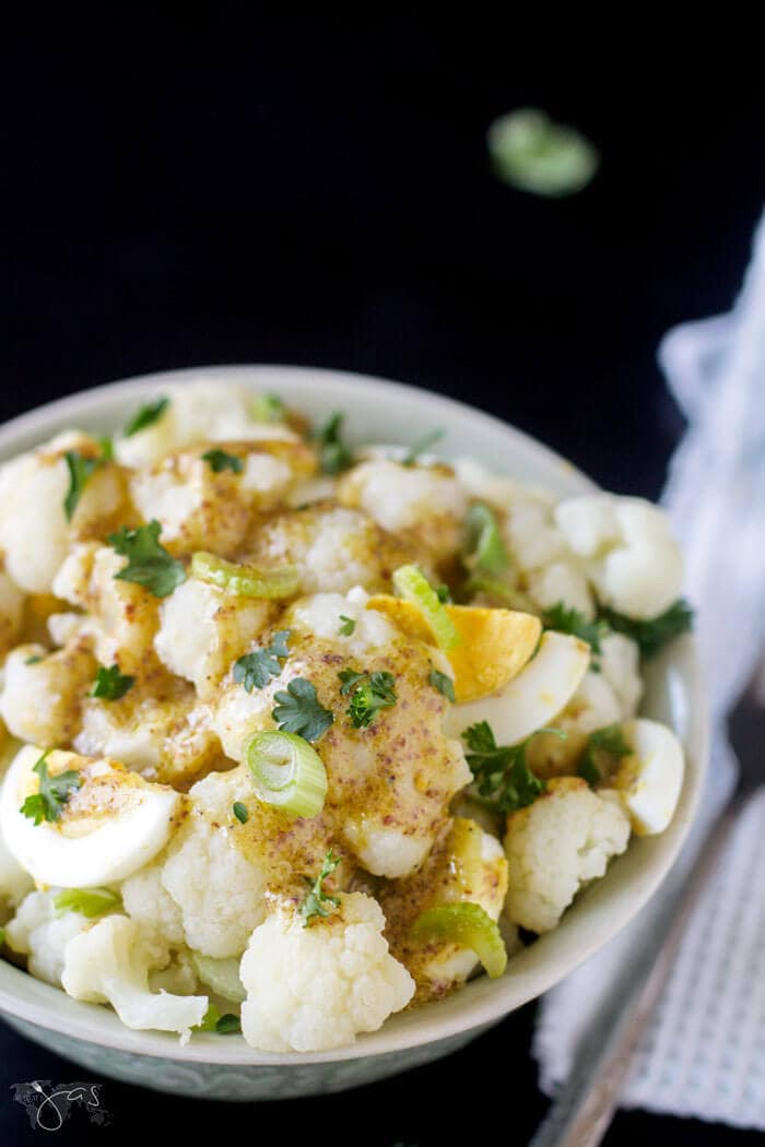 A shot of salad with cauliflower in a bowl with fork