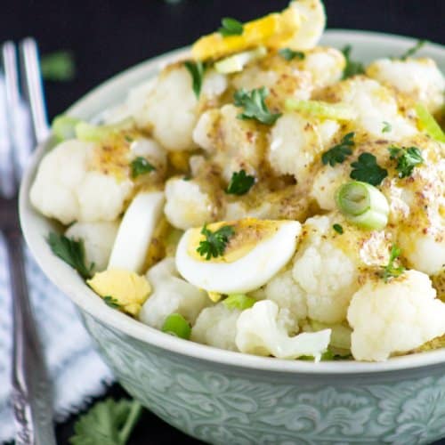 cauliflower mock potato salad in a bowl on a black background