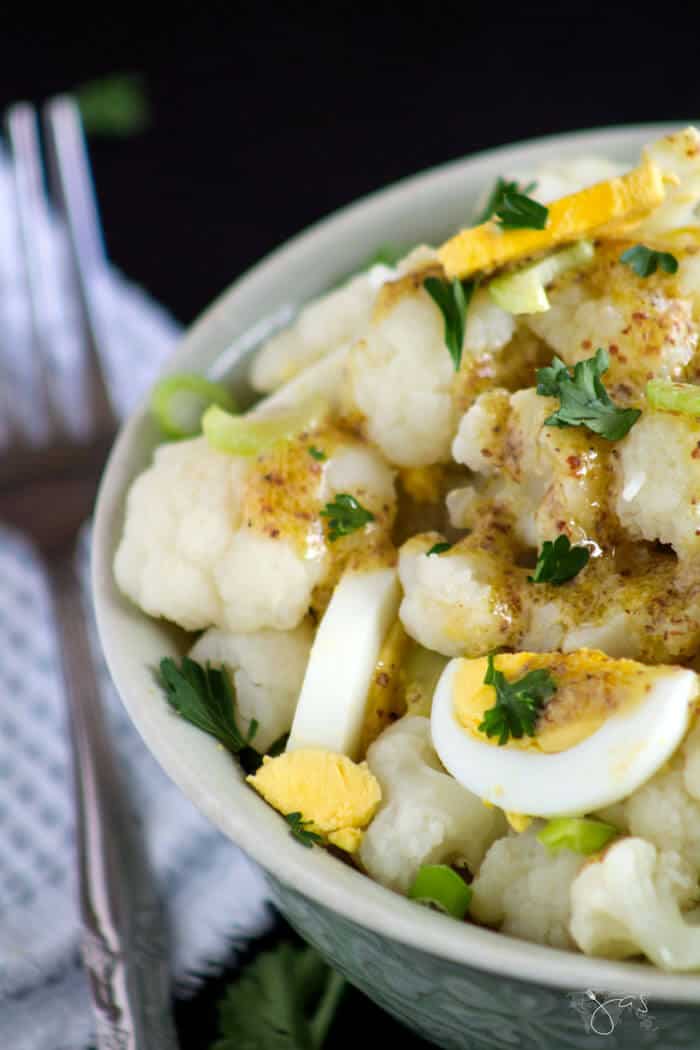 Close up shot of the bowl with cauliflower salad with hard-boiled eggs and dressing