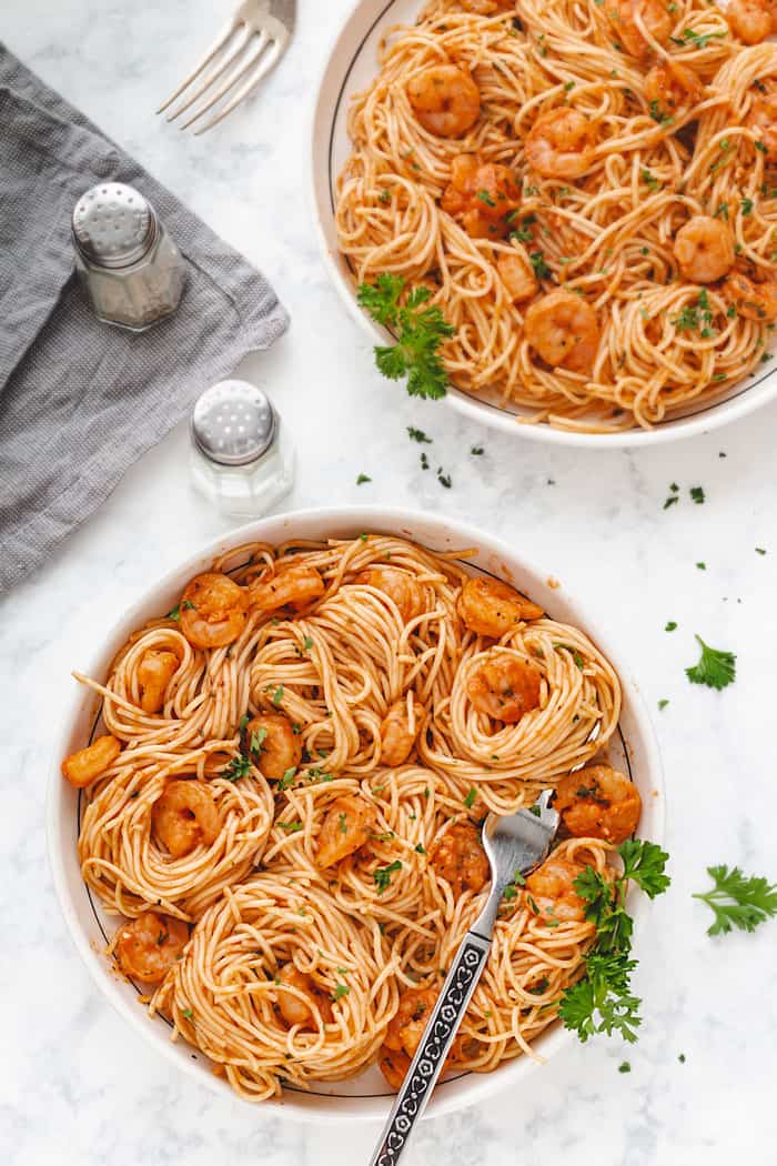 Overhead shot of two pasta and shrimp servings.