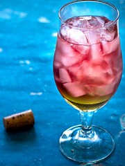 Peach Sangria Bellini in a glass on a blue background
