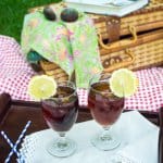 Two glasses with drinks at a picnic.