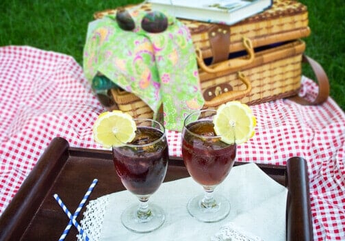 Two glasses with drinks at a picnic.