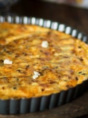 A close up of quiche in a metal tart pan.