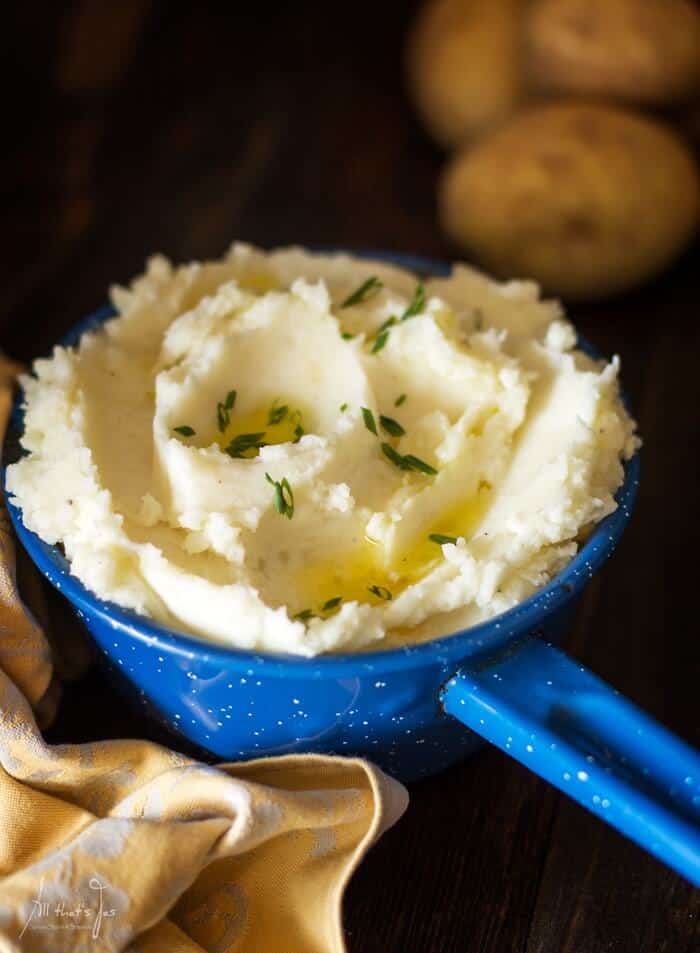 A blue pot with a handle filled with mashed potatoes