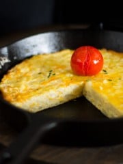 cauliflower frittata and tomato in cast-iron pan