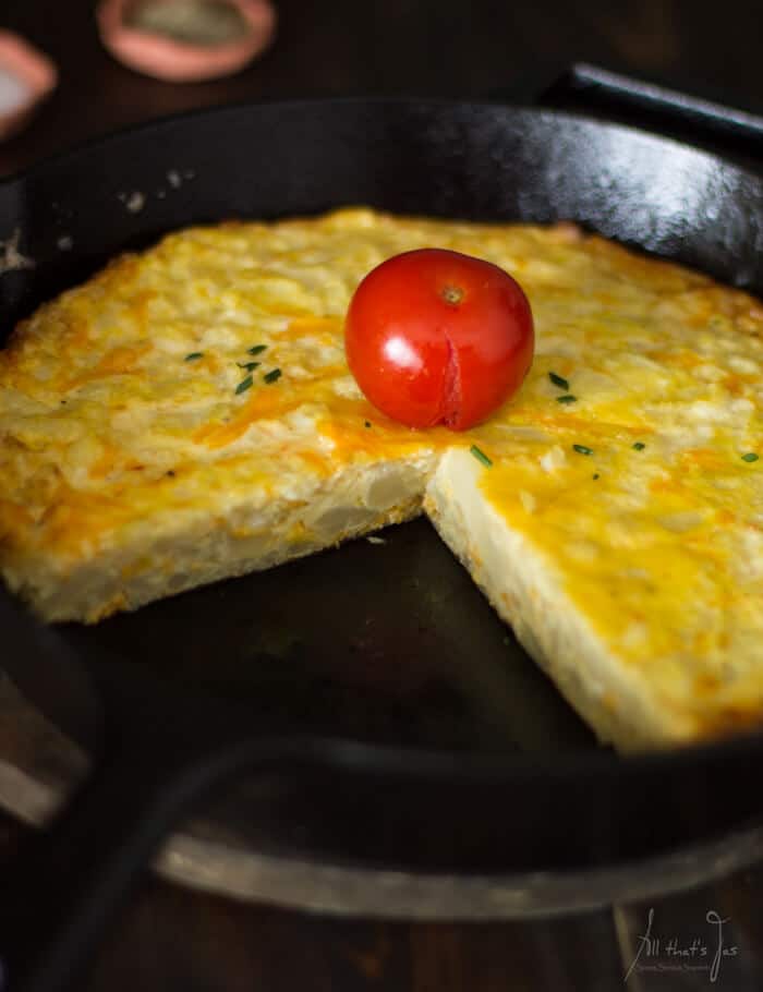 Frittata piece in a pan and tomato.