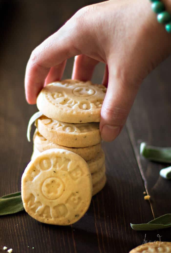 A close up of stacked cookies with a hand