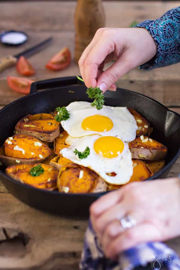A cast-iron pan with sweet potatoes and eggs