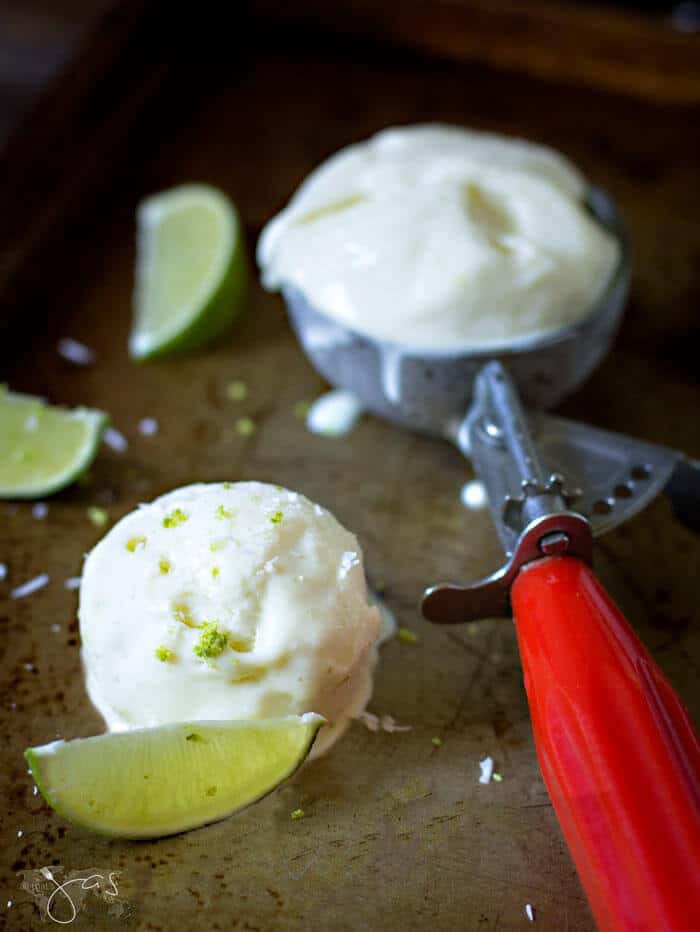 A photo of an ice cream scoop and the scooper with lime wedges