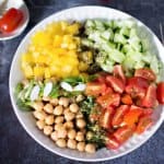 A bowl of chickpea salad with peppers and tomatoes