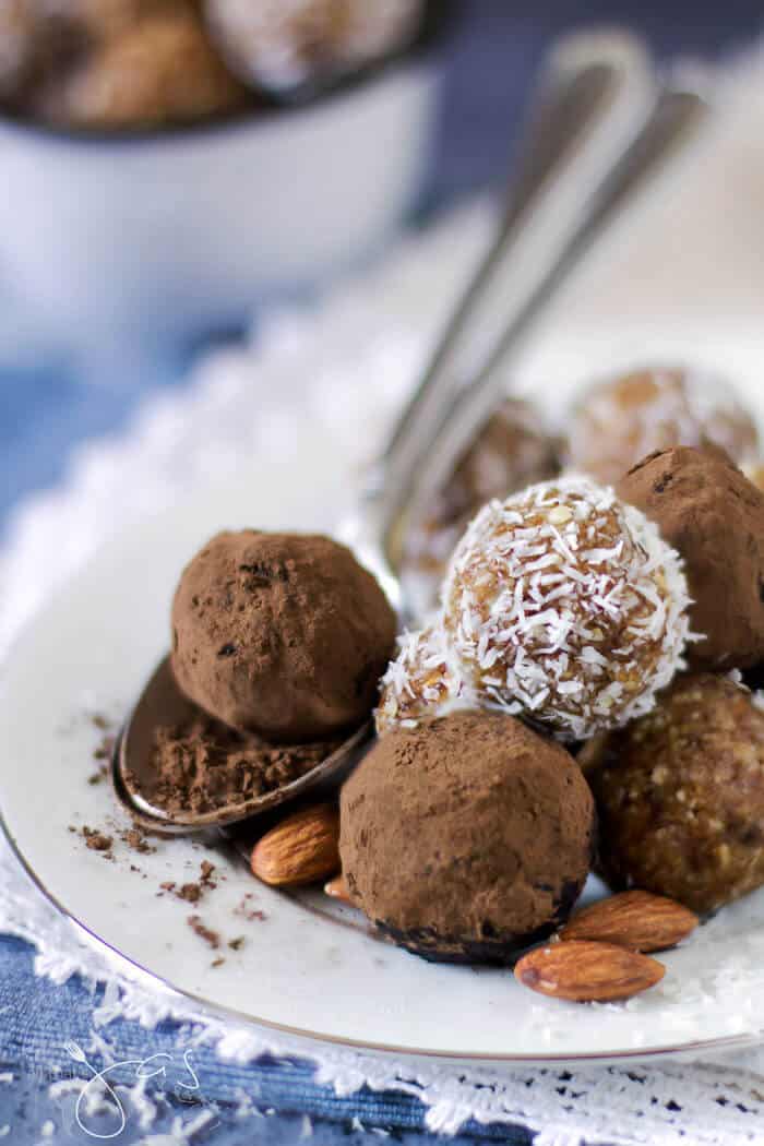 A close up of energy balls on a plate and in a spoon