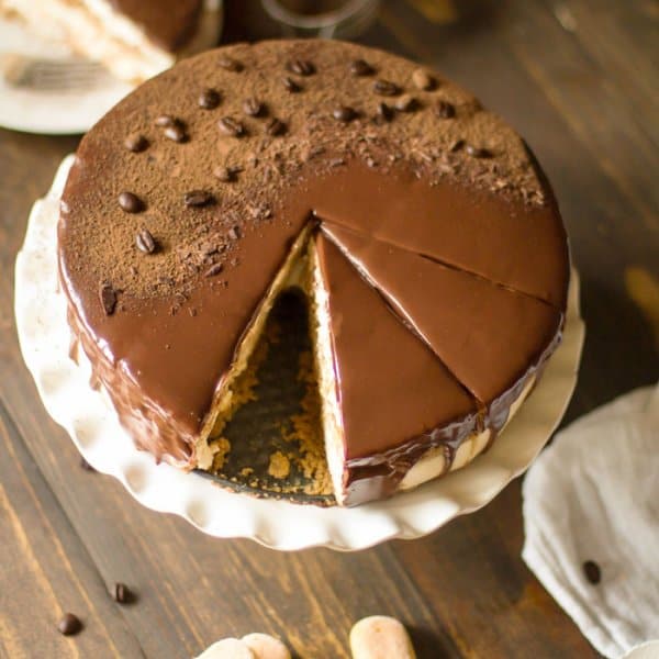 An overhead photo of a cake on a stand and lady finger cookies