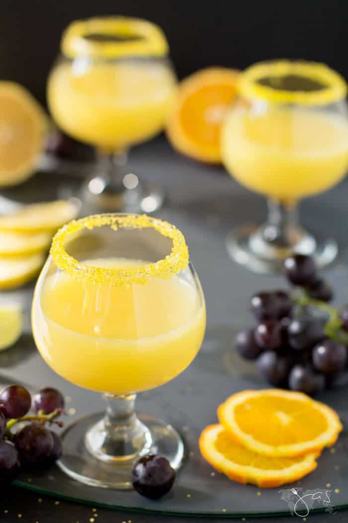 A close up of orange cocktail in glasses and orange slices