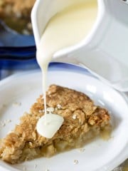 Homemade vanilla sauce being poured over warm apple pie.