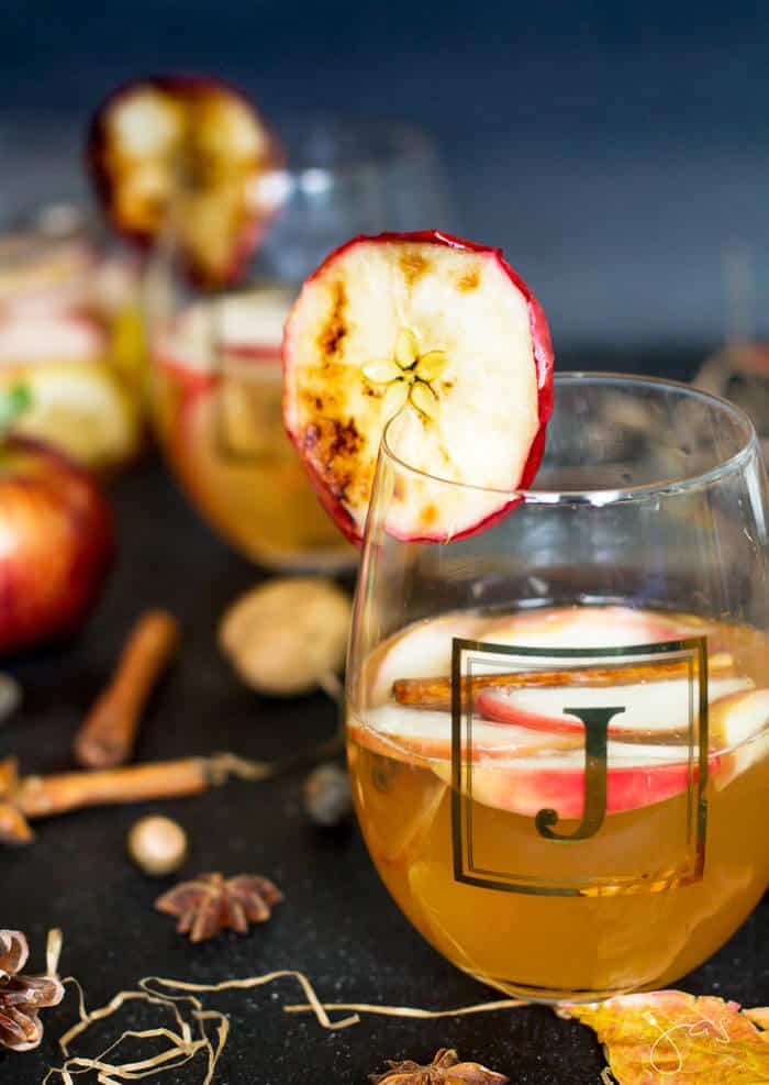 Apple punch with beer and spiced with cinnamon, cloves and lemon in a glass