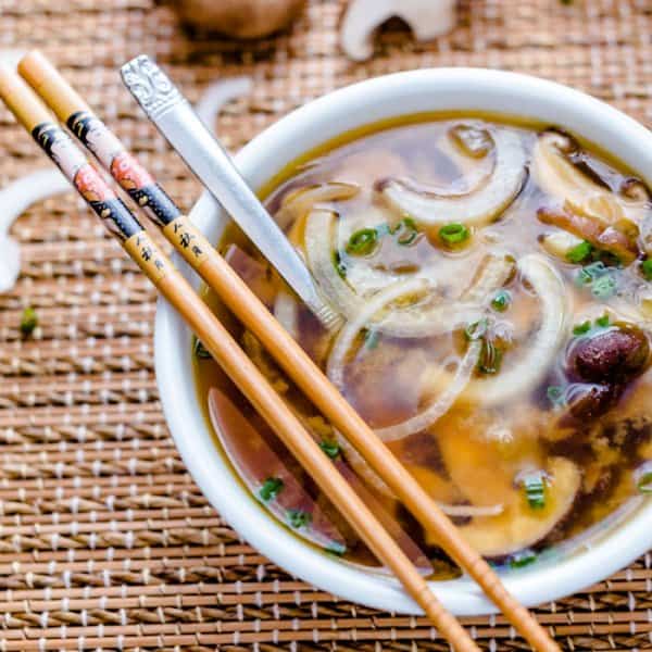 Japanese soup with onions and mushrooms in a bowl with chopsticks