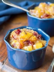 Two bowls with mango chutney on a wooden table