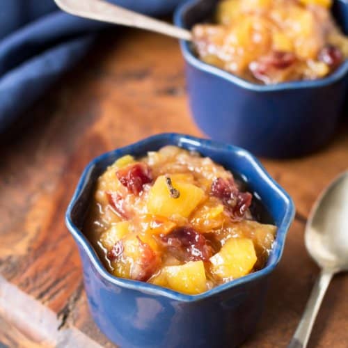 Two blue ramekins with mango chutney and spoons