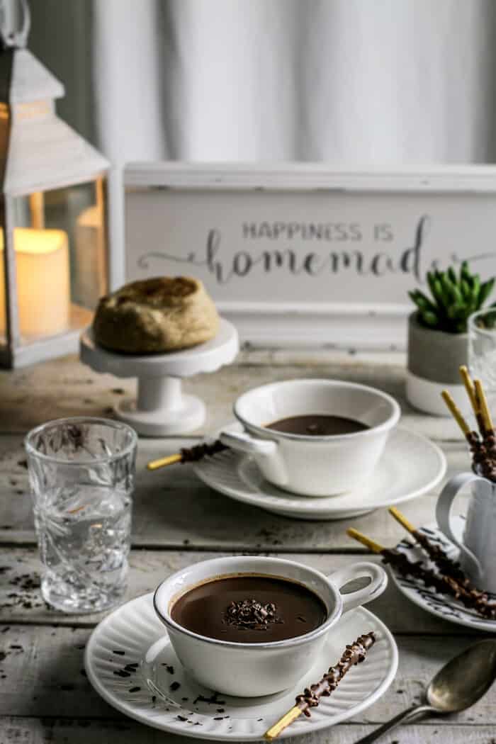 A rustic table setting with cups of hot chocolate.