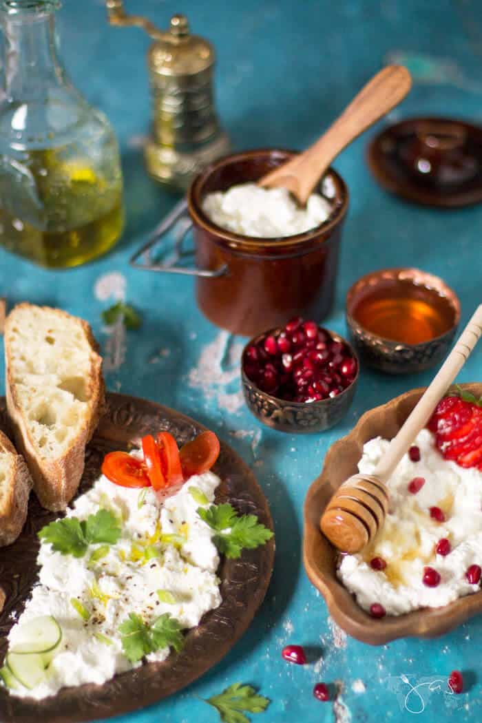 A phot of farmer;s cheese served with different sides on a green background.