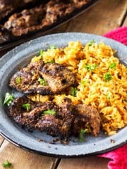 A plate with rice and meat on a table