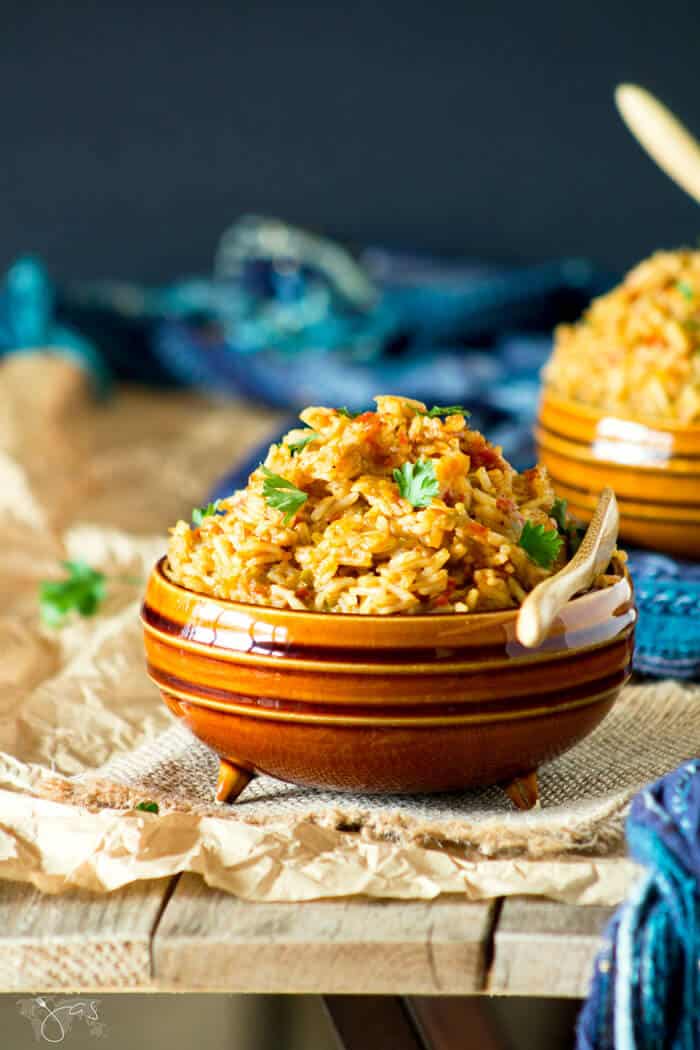 A front shot of a bowl of jollof rice on a wooden background.