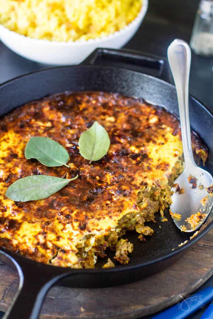 Skillet with bobotie being served.