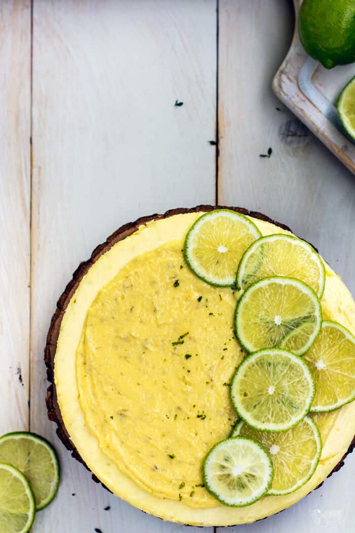 Cheesecake with sliced lime rounds on a white background, from above
