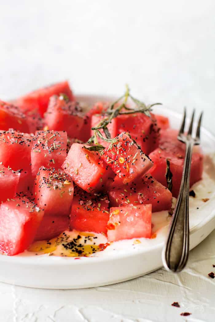 Israeli summer salad served on a plate with a fork, ready to be eaten.