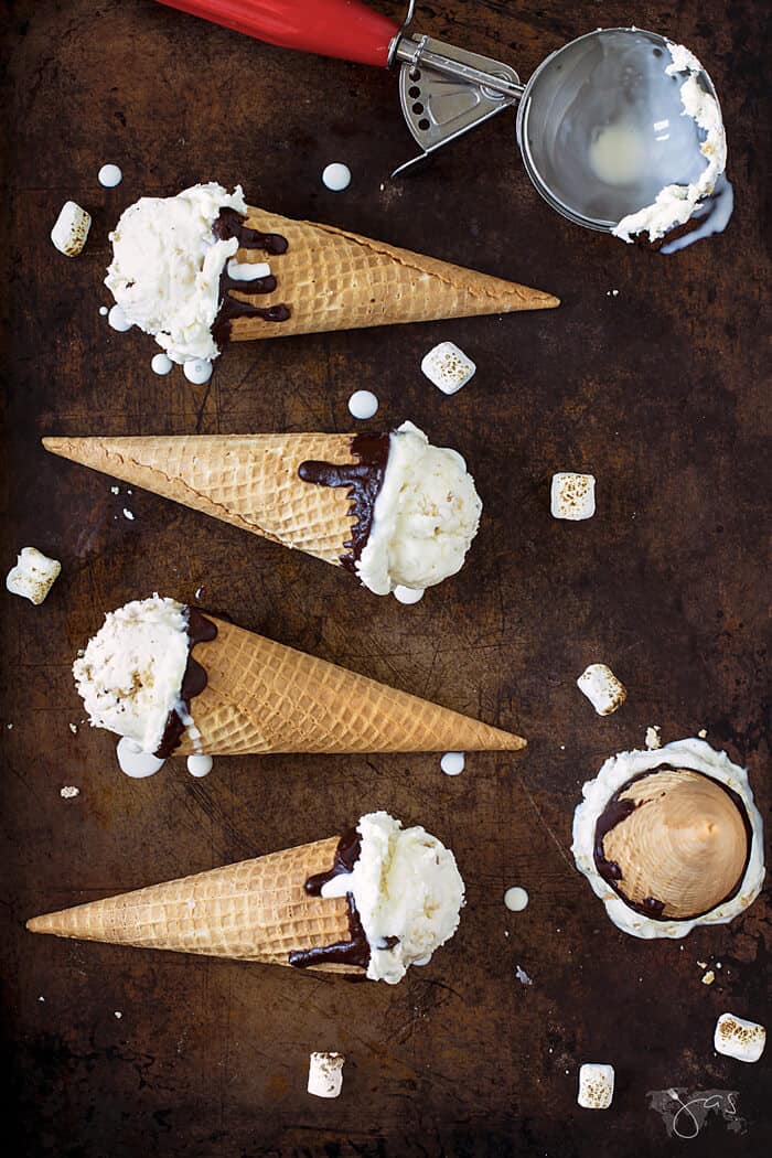 S'mores ice cream cones lined up on a brown background