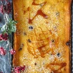 An overhead shot of cranberry tart with caramel garnishes and Christmas decorations.