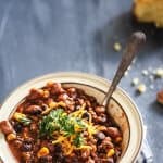 Chili served in a bowl with a spoon on a blue background