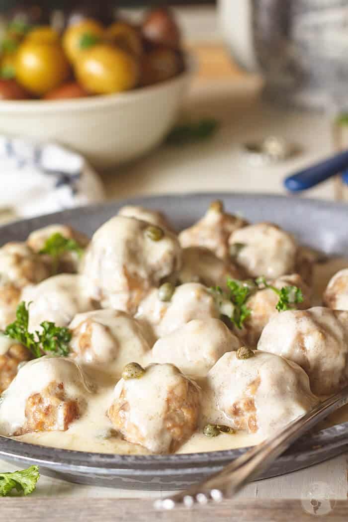 A close-up shot of the meatballs in white gravy.