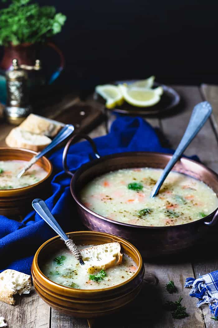 ¾ view of served soup in brown bowls with spoons