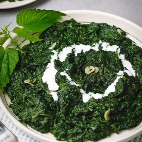 A plate of creamy nettle with a cream swirl.