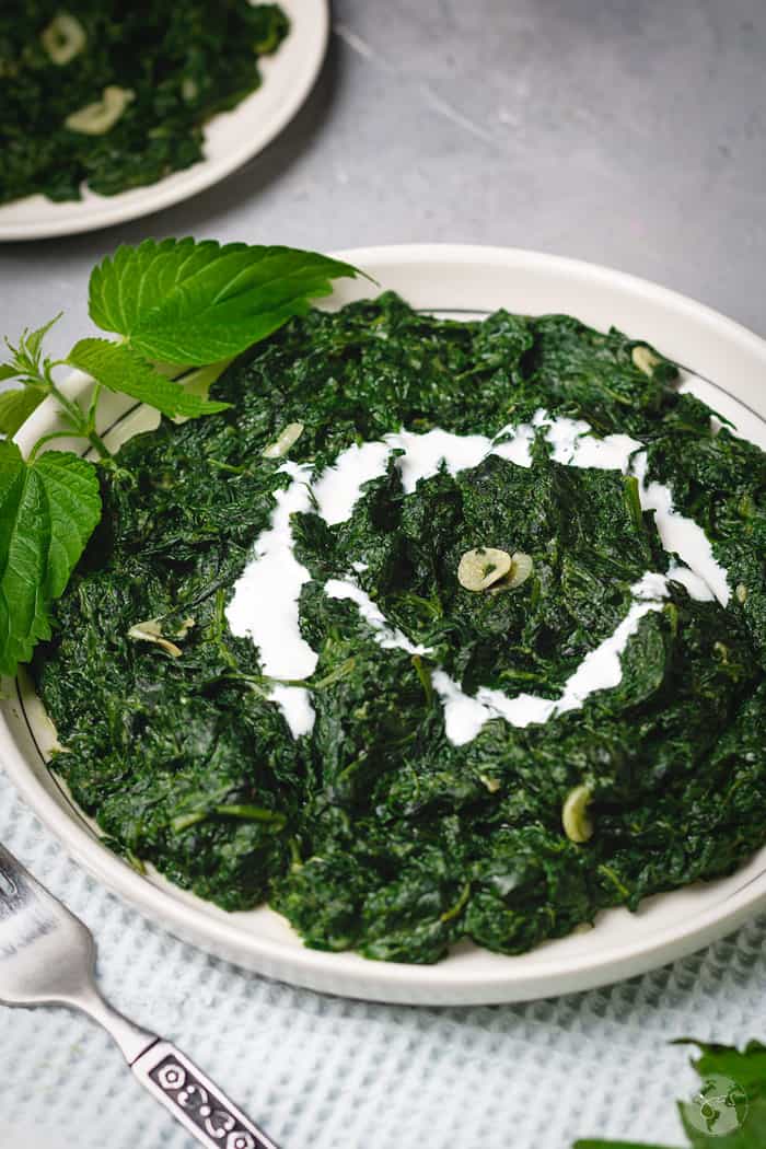 A plate of creamy nettle with a cream swirl.