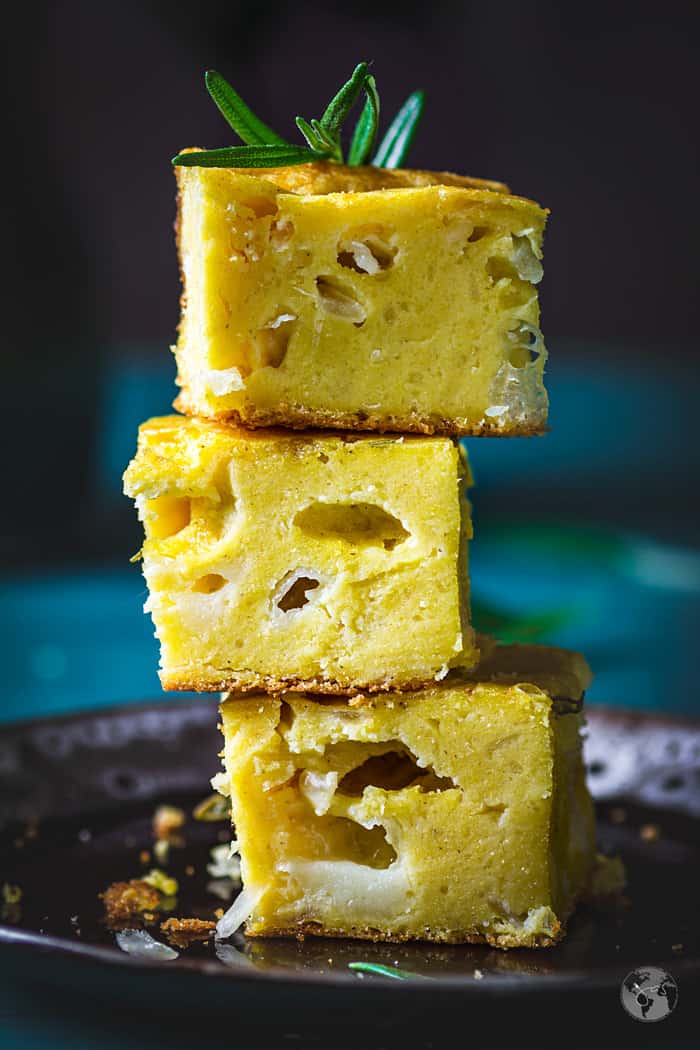 Stacked squares of cheese and onion cornbread with rosemary.