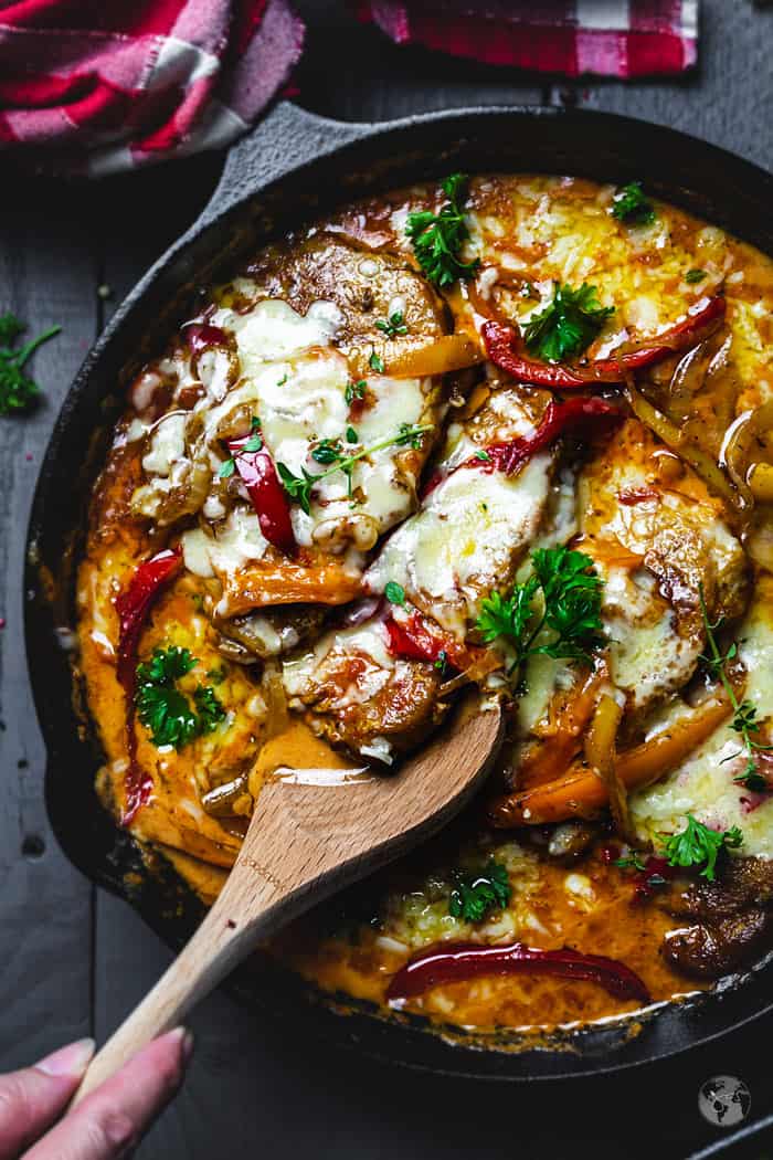 Close-up shot of the pan with German schnitzel and a wooden spoon