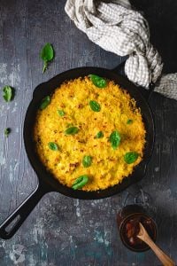 Corn pie skillet dish on a gray background with tan kitchen towel.