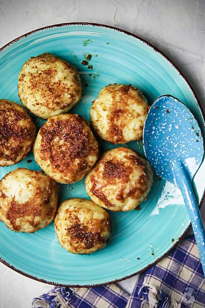 A teal plate with plum dumplings