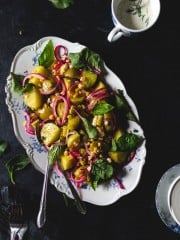 Danish Warm Potato Salad with Corn and Baby Greens on a platter - overhead