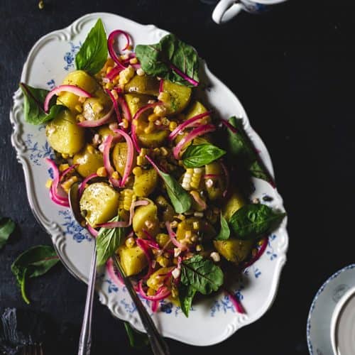 Danish Warm Potato Salad with Corn and Baby Greens on a platter - overhead