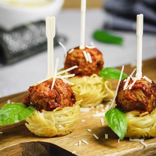 Spaghetti nests appetizer with meatballs with toothpicks.