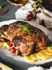 pork roast on a serving platter with roasted vegetables